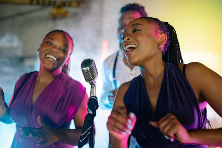 Energetic live performance by African American singers with vintage microphone, vibrant lighting.