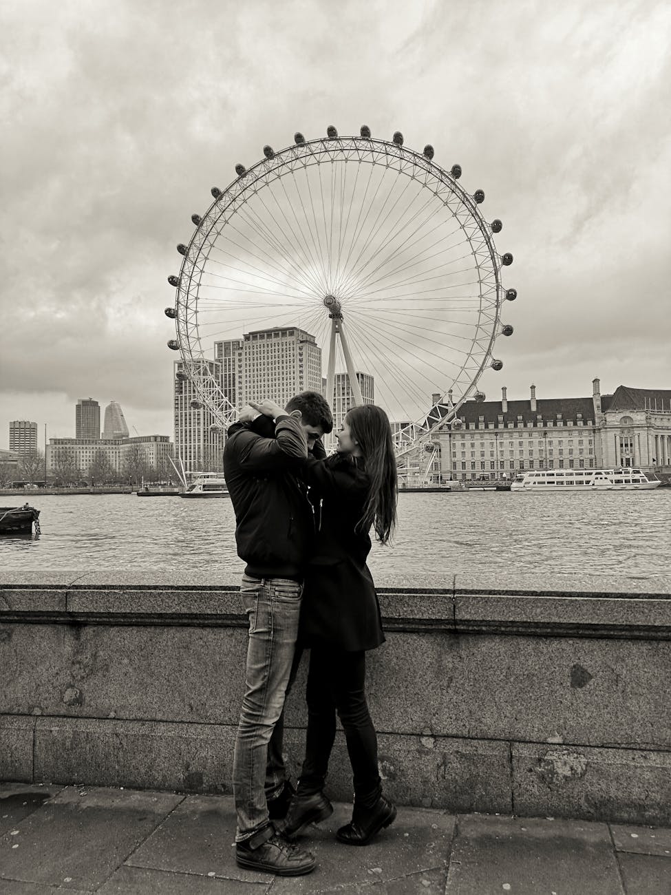 A romantic couple embracing near the iconic London Eye, capturing love and urban charm.