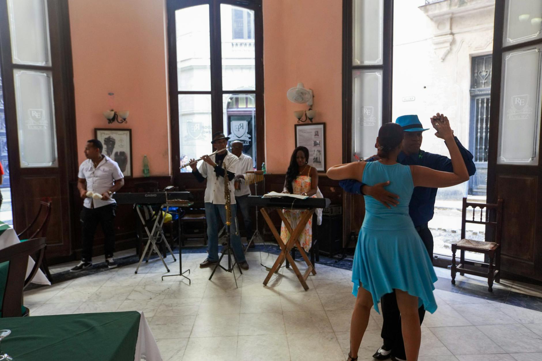 A vibrant scene of dancers and musicians performing indoors with Latin flair.
