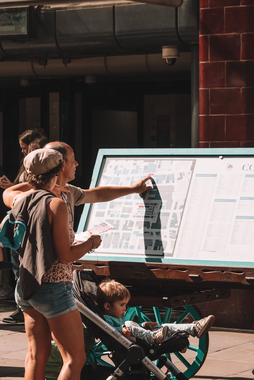 Family exploring London with a street map outdoors on a sunny day.