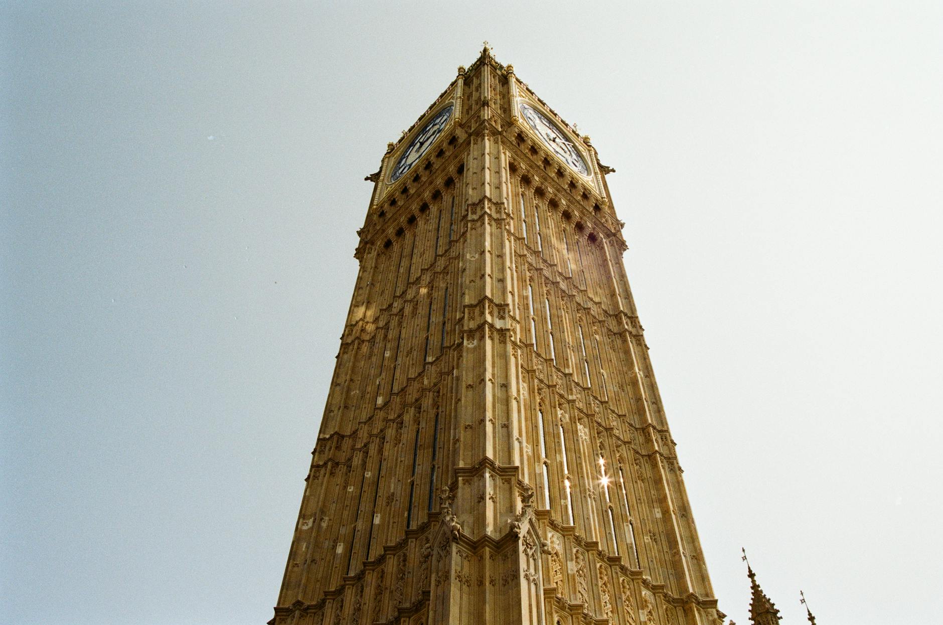 View of Big Ben in London from a low angle on a clear day, showcasing its architectural beauty.