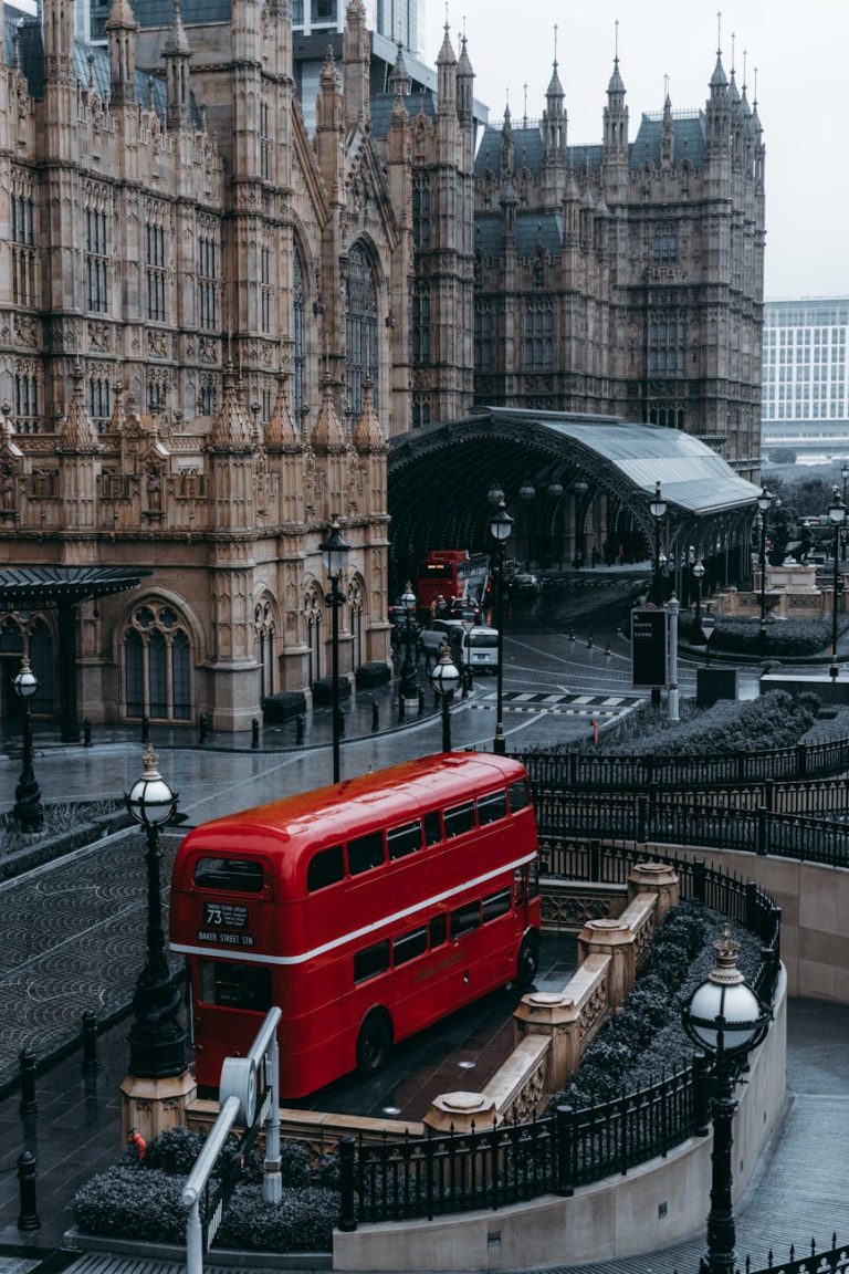 Iconic red double-decker bus near the Gothic Westminster Palace in London.