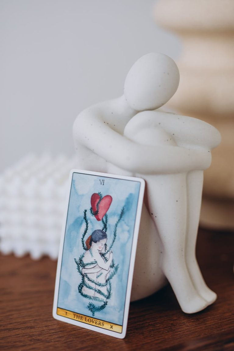 Close-up of a Lovers tarot card with a minimalist sculpture, evoking a sense of romance and contemplation.