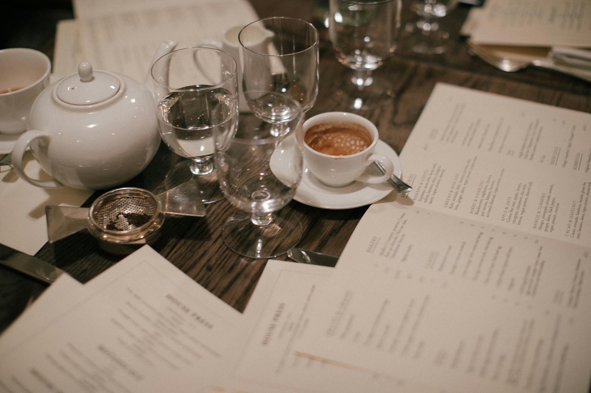 A sophisticated coffee and tea setup with menus and glassware, perfect for a refined gathering.