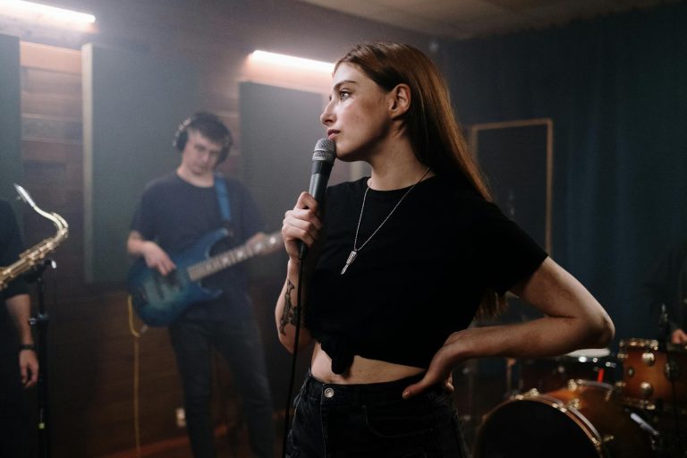 Female singer with microphone in dynamic band performance scene indoors, showcasing live music energy.