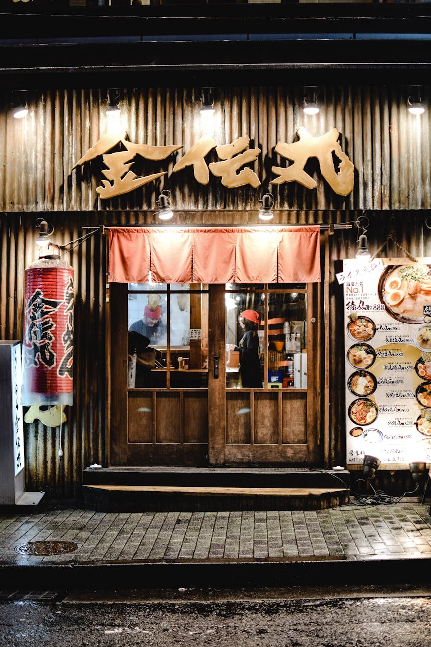 Night view of a traditional Japanese izakaya with glowing signage and inviting entrance.