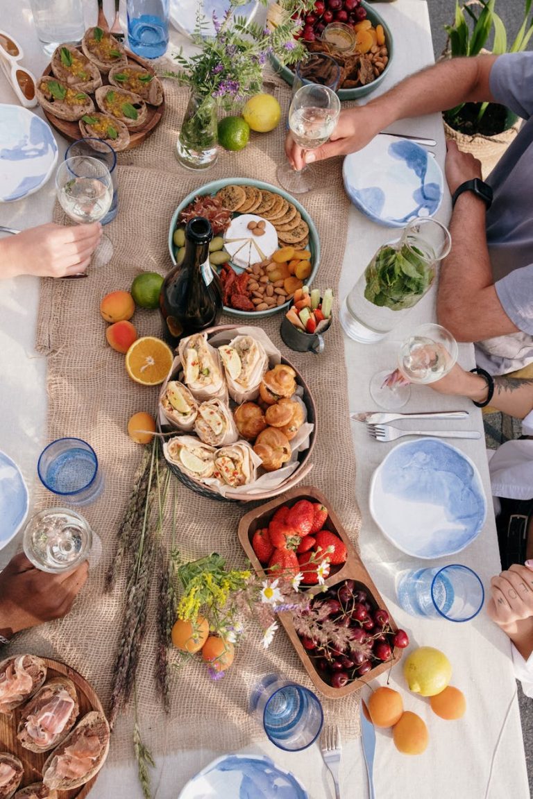 Top view of a lively outdoor brunch with friends, featuring diverse dishes and fresh drinks.