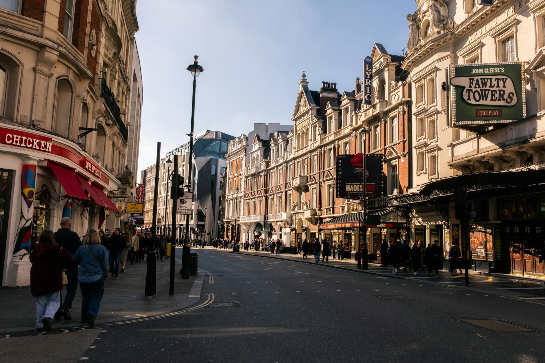 Bustling street in London featuring historic theatres and vibrant city life.
