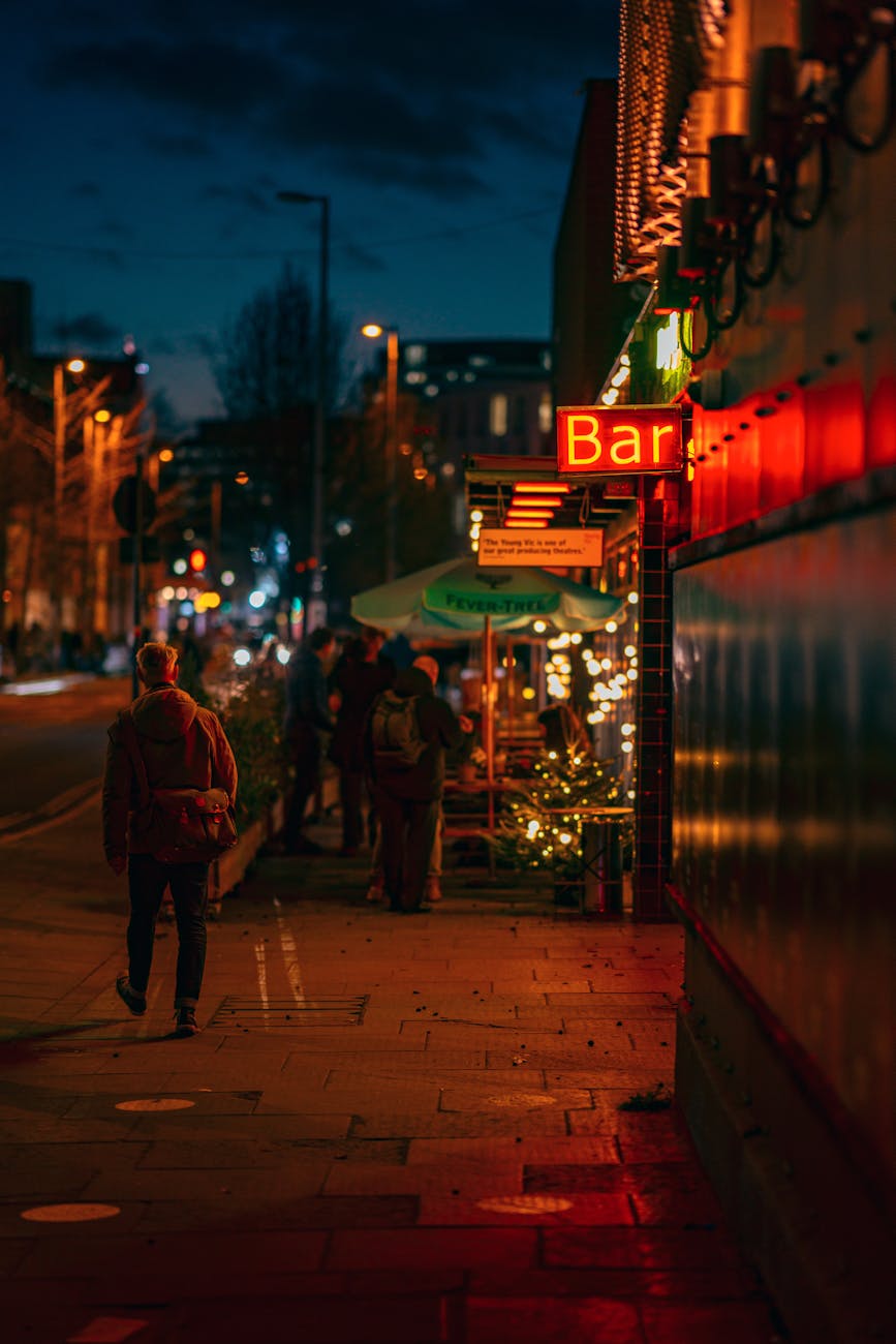Vibrant scene of people enjoying nightlife outside a bar in London.