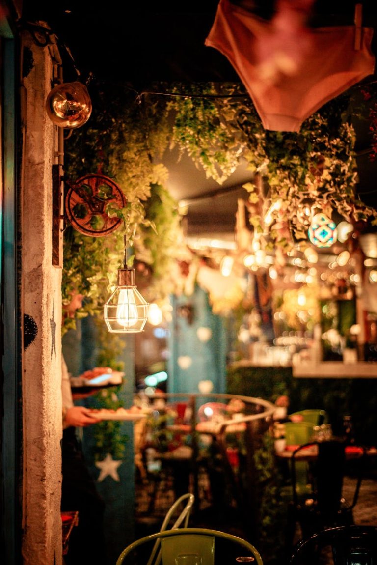 Warm and inviting cafe with lush plants and atmospheric lighting. Perfect for a cozy evening out.
