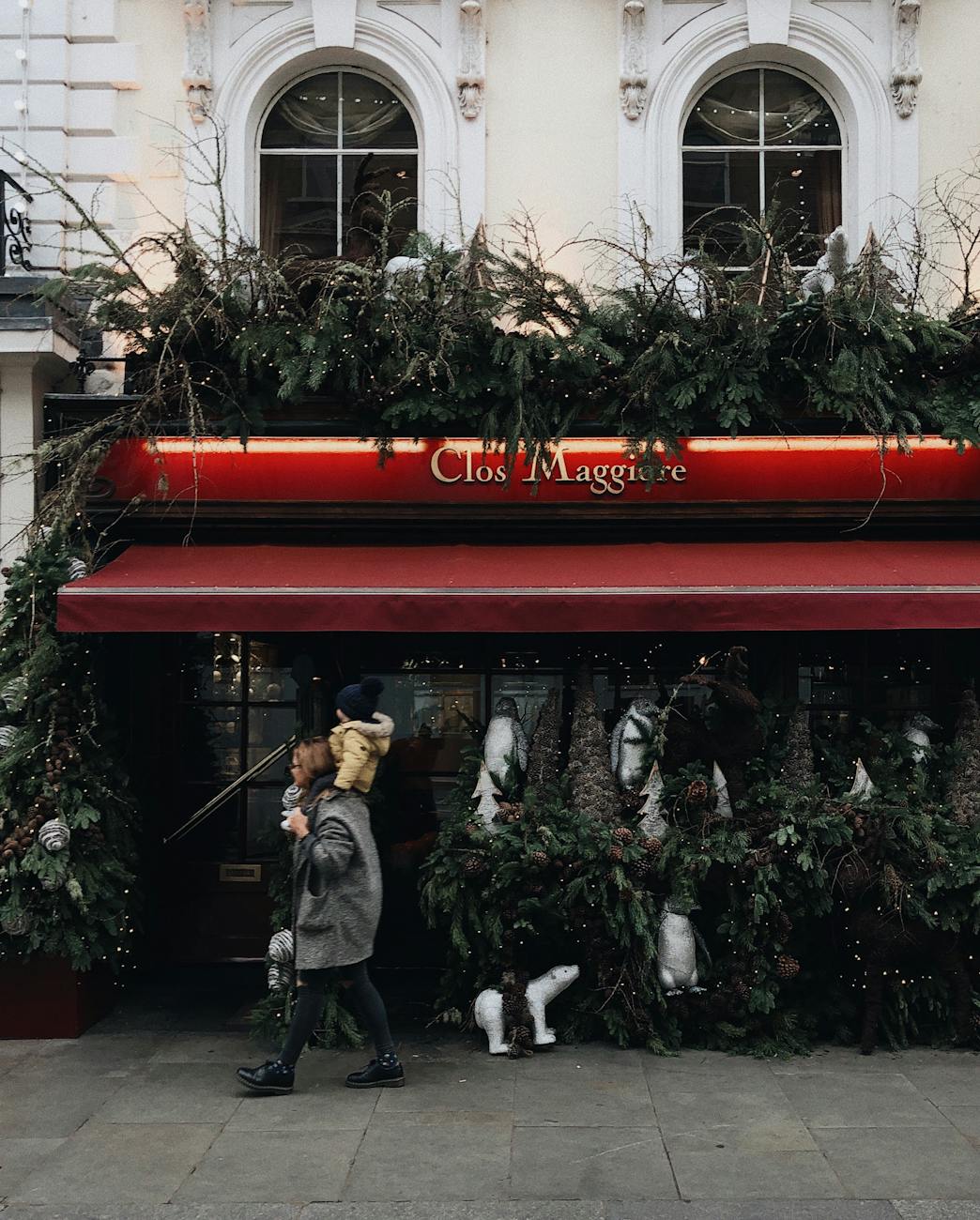 A family strolls past a festively decorated shop in Covent Garden, London, during the holiday season.