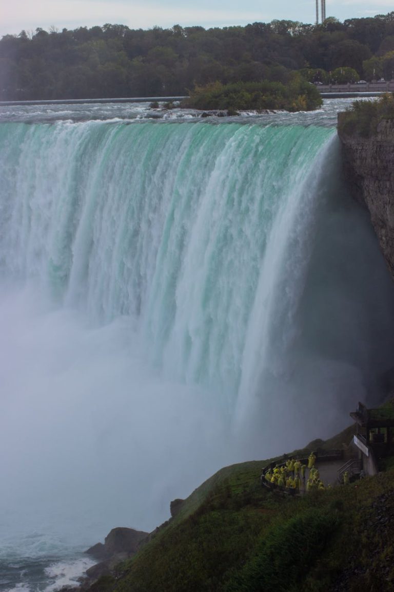 Stunning view of Niagara Falls, capturing the powerful cascade and mist in a serene autumn backdrop.