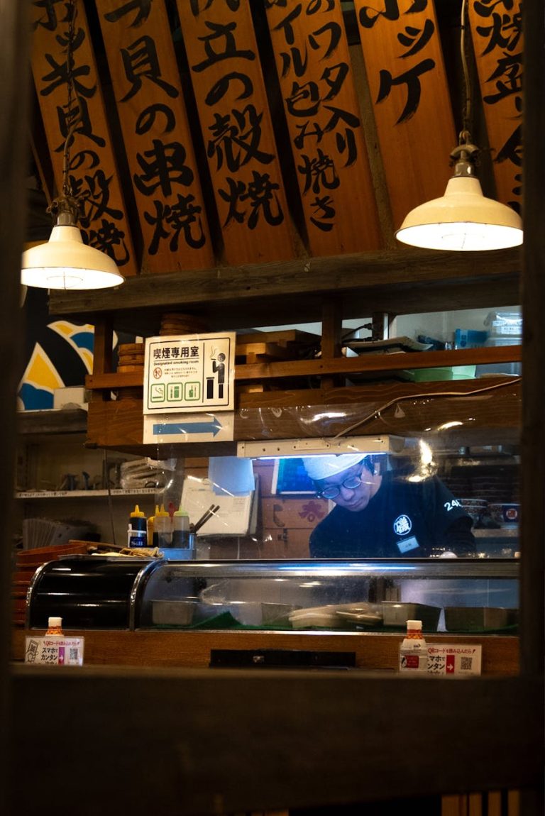 A sushi chef meticulously preparing dishes in an authentic Tokyo restaurant setting.