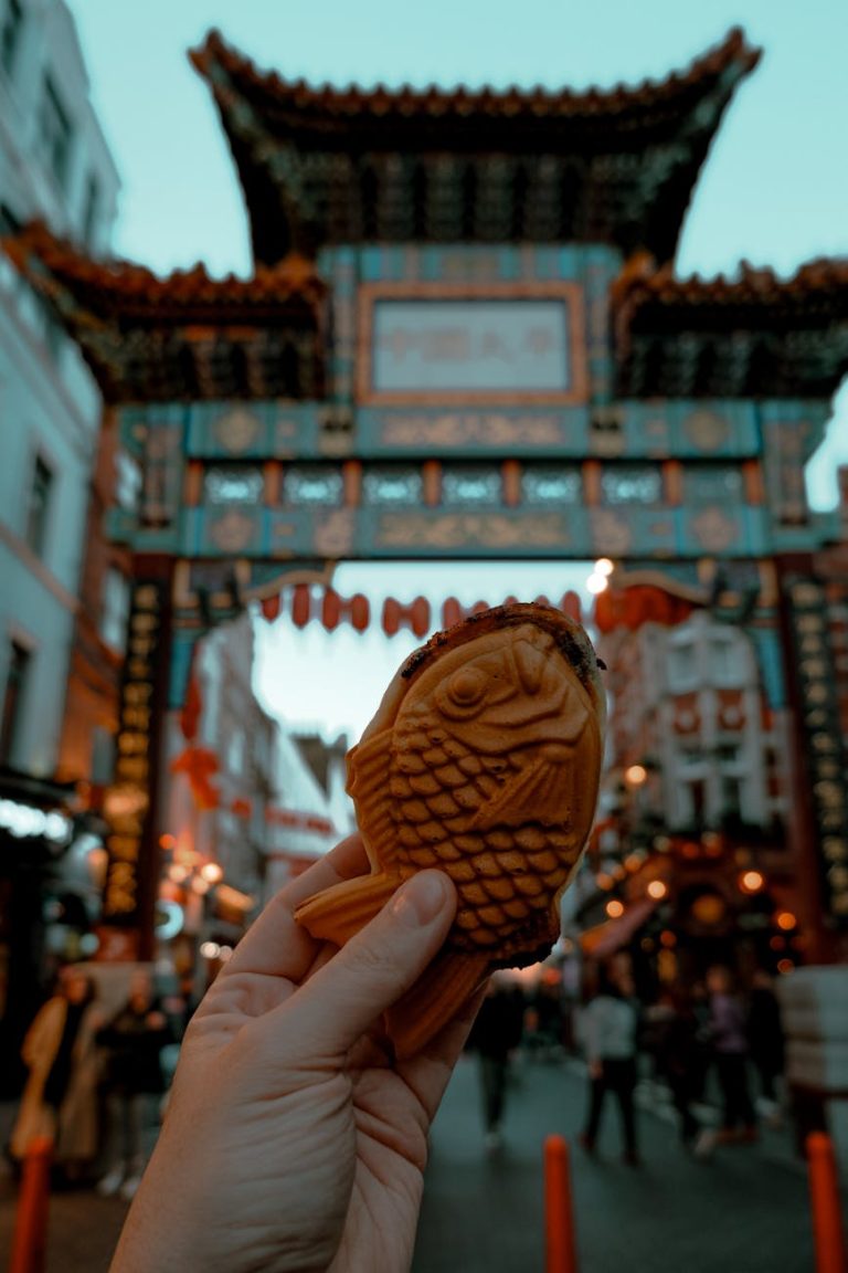 Taiyaki held against Chinatown gate in London during the evening, capturing cultural essence.